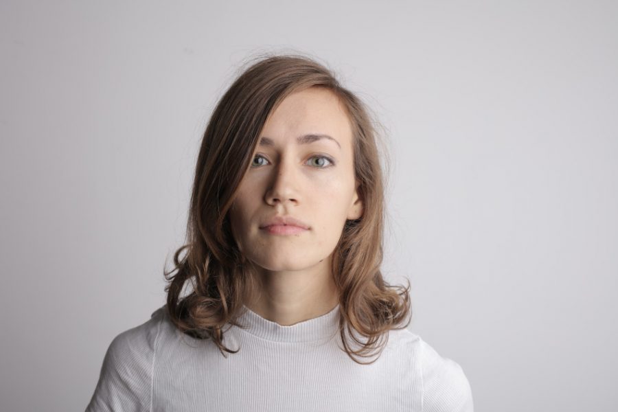 Young woman with shoulder-length brown hair, wearing a white turtleneck, looking directly at the camera against a plain background, representing a professional approach to home buying and mortgage services.
