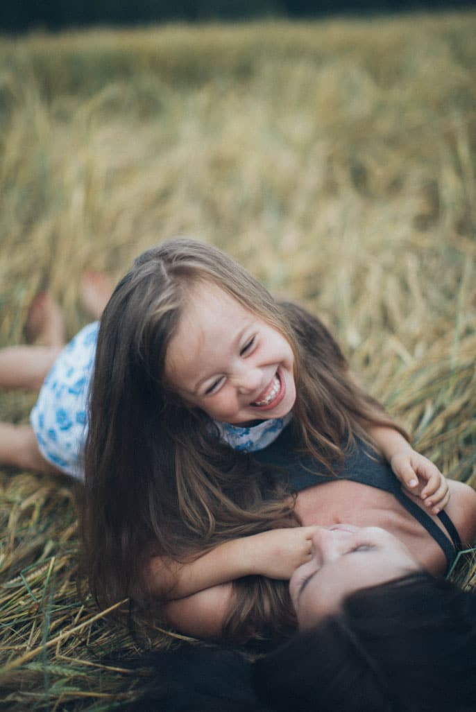 Mother and daughter playing together in a field, showcasing joy and connection, emphasizing home and family warmth relevant to home-selling tips.