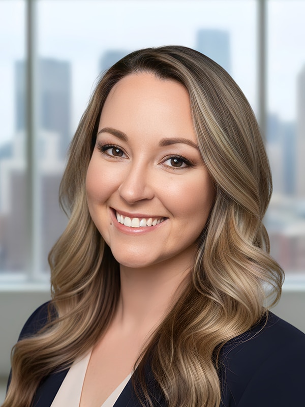 Kelly Wilcoxon, Mortgage Loan Originator at Loan Velocity, smiling portrait with city skyline background, representing services for homeownership in Richmond Hill and Savannah areas.