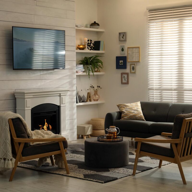 Cozy living room interior featuring a comfortable sofa, two wooden chairs, a coffee table with a teapot, and a fireplace, emphasizing a warm and inviting atmosphere for financial discussions.